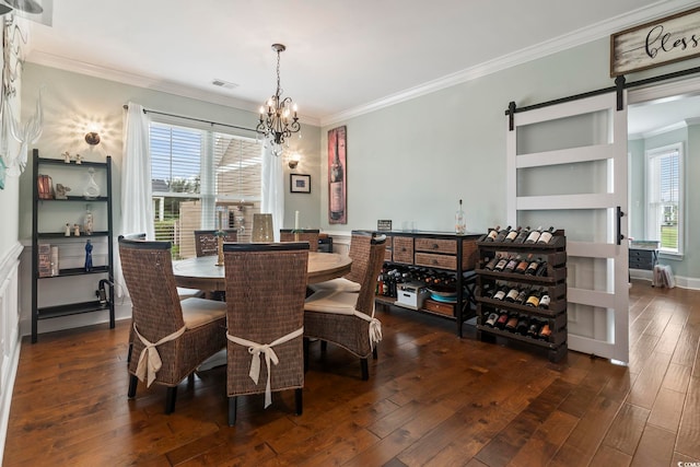 dining space with crown molding, a barn door, dark hardwood / wood-style floors, and a notable chandelier