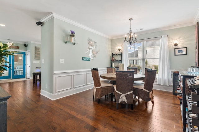 dining space featuring an inviting chandelier, crown molding, and dark wood-type flooring