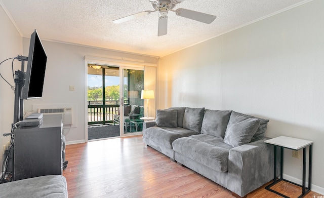 living room with ceiling fan, a wall mounted AC, a textured ceiling, light hardwood / wood-style flooring, and crown molding