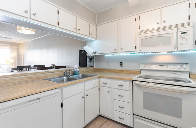 kitchen featuring white cabinets, white appliances, light tile patterned floors, a textured ceiling, and sink