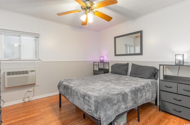 bedroom with light hardwood / wood-style flooring, a textured ceiling, ceiling fan, and crown molding