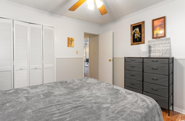 bedroom featuring ceiling fan, a textured ceiling, a closet, and ornamental molding