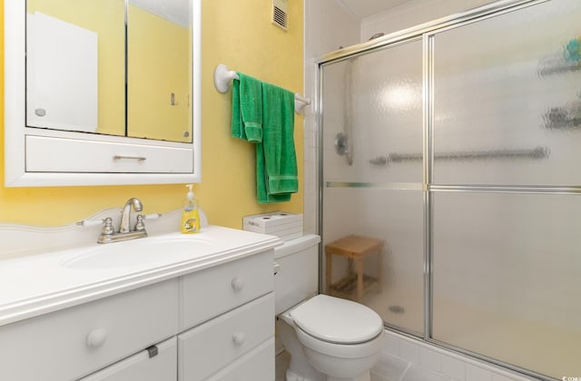 bathroom with tile patterned flooring, vanity, toilet, and a shower with shower door