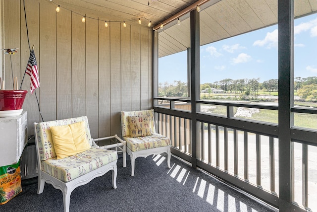 sunroom / solarium featuring rail lighting, wooden ceiling, and a wealth of natural light