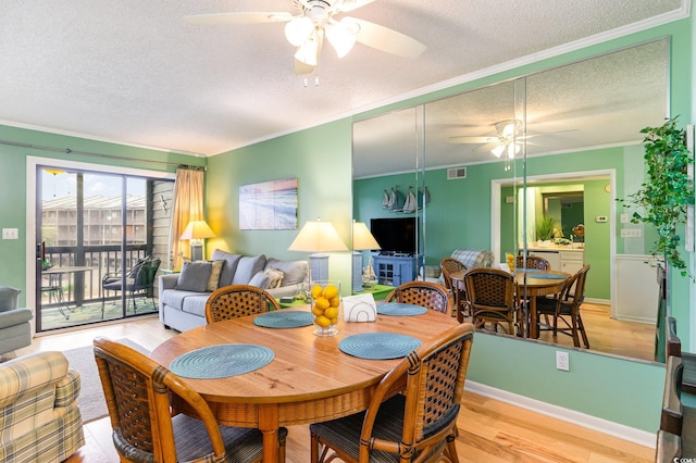 dining area with ceiling fan, a textured ceiling, crown molding, and light hardwood / wood-style floors