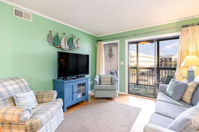 living room with a textured ceiling, light hardwood / wood-style flooring, and crown molding