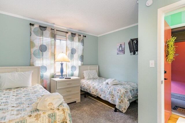 carpeted bedroom with a textured ceiling and ornamental molding