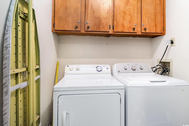 washroom featuring cabinets and washing machine and dryer