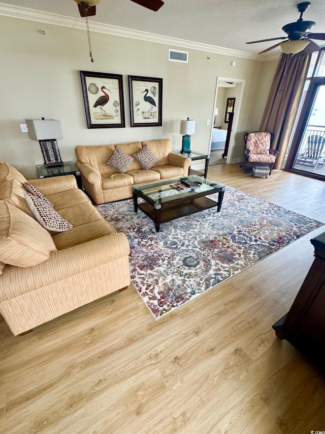 living room featuring a textured ceiling, light hardwood / wood-style floors, ceiling fan, and crown molding