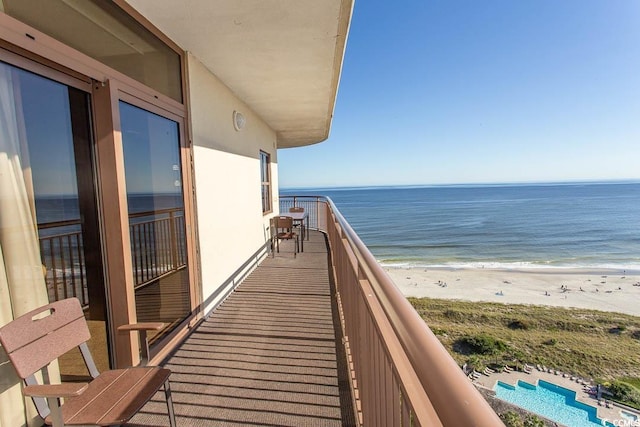 balcony with a water view and a view of the beach