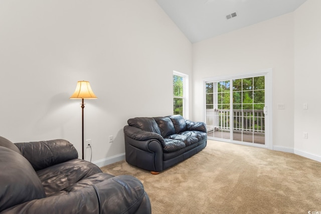 carpeted living room featuring high vaulted ceiling