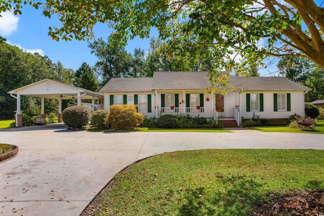 ranch-style house with a front lawn, a carport, and covered porch