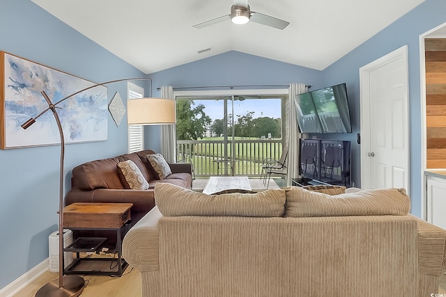 living room featuring light hardwood / wood-style floors, vaulted ceiling, and ceiling fan