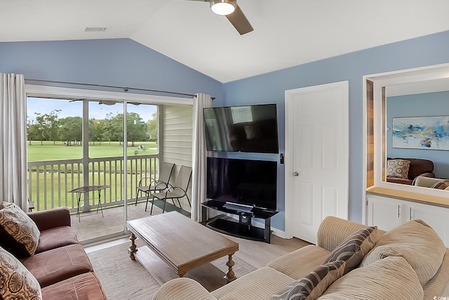 living room featuring ceiling fan, lofted ceiling, and light wood-type flooring