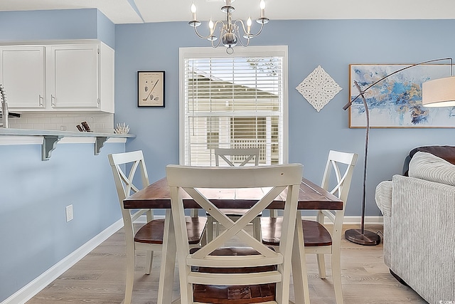 dining room with an inviting chandelier and light hardwood / wood-style flooring