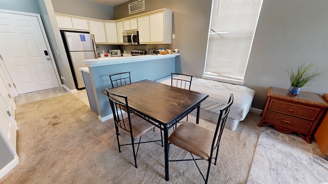 dining room featuring light colored carpet