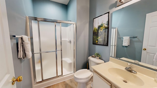 bathroom featuring vanity, toilet, an enclosed shower, and wood-type flooring