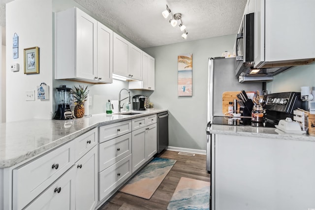 kitchen featuring stainless steel appliances, white cabinetry, sink, and light stone counters