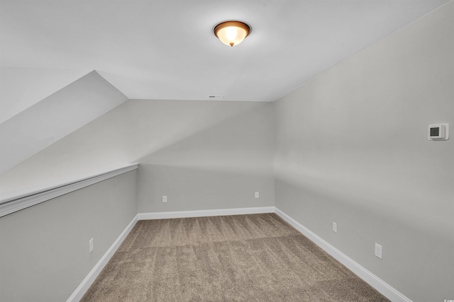 additional living space with carpet flooring and lofted ceiling