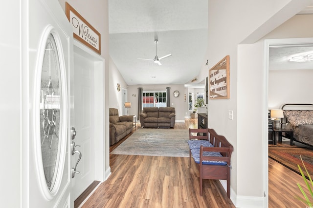 living room featuring vaulted ceiling, ceiling fan, and wood-type flooring