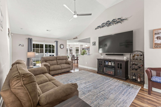 living room featuring a textured ceiling, ceiling fan, lofted ceiling, and hardwood / wood-style floors