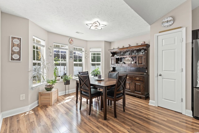 dining area featuring a textured ceiling and hardwood / wood-style floors