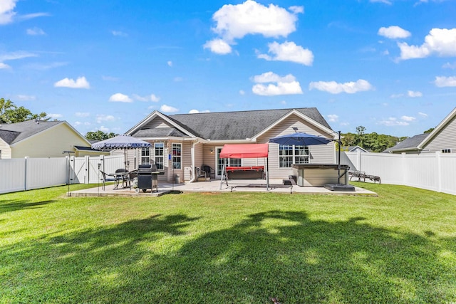 rear view of property with a hot tub, a lawn, and a patio