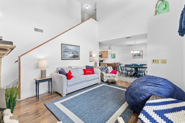 living room with hardwood / wood-style floors, a high ceiling, and a notable chandelier