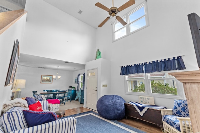 living room featuring a high ceiling, plenty of natural light, ceiling fan, and hardwood / wood-style floors