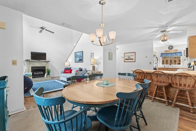 dining space with a chandelier, a textured ceiling, and light hardwood / wood-style flooring