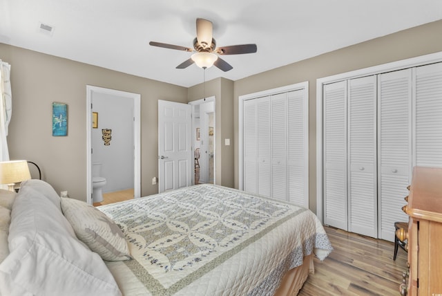 bedroom with connected bathroom, ceiling fan, multiple closets, and light wood-type flooring