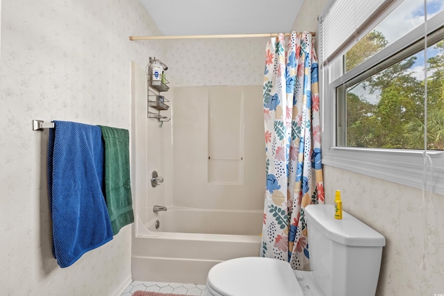 bathroom featuring toilet, shower / bath combo with shower curtain, a healthy amount of sunlight, and tile patterned flooring