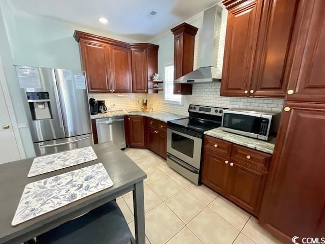 kitchen with sink, wall chimney exhaust hood, backsplash, appliances with stainless steel finishes, and ornate columns