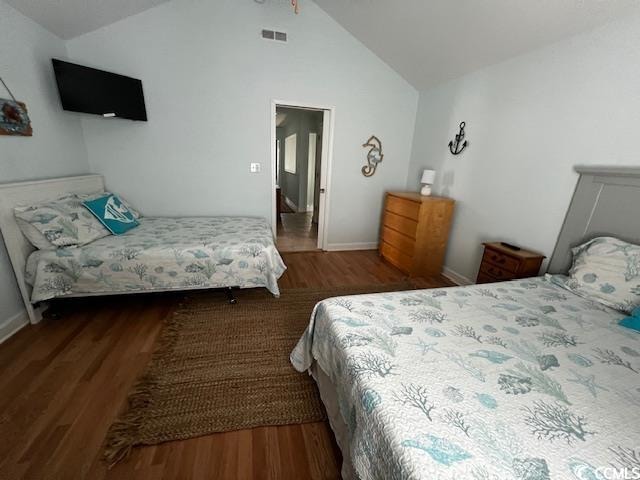 bedroom with vaulted ceiling and dark hardwood / wood-style flooring