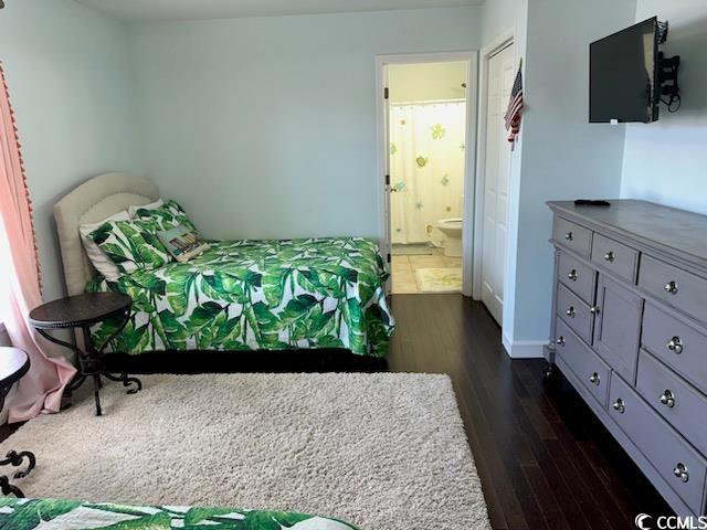 bedroom featuring dark hardwood / wood-style flooring and ensuite bathroom