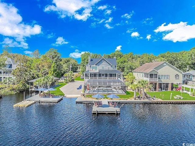 rear view of house featuring a lawn and a water view