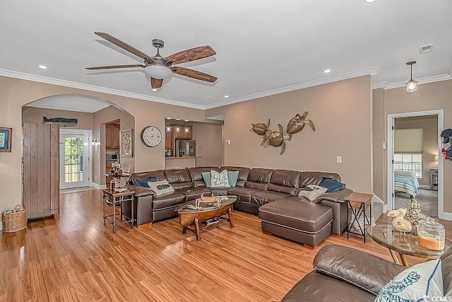 living room with light wood-type flooring, crown molding, and ceiling fan