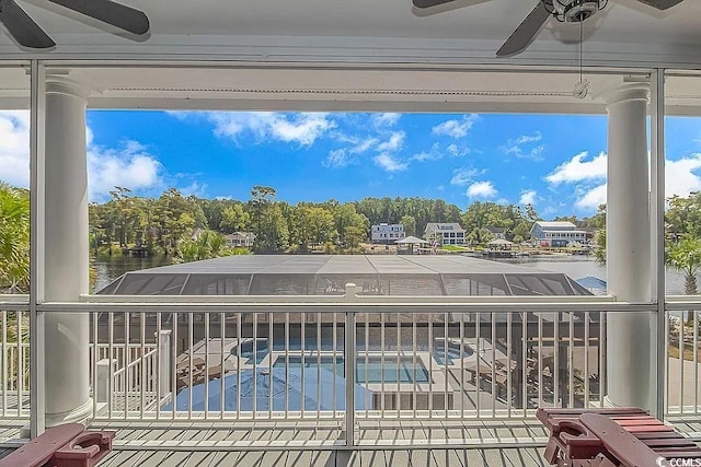 view of swimming pool with a water view and ceiling fan