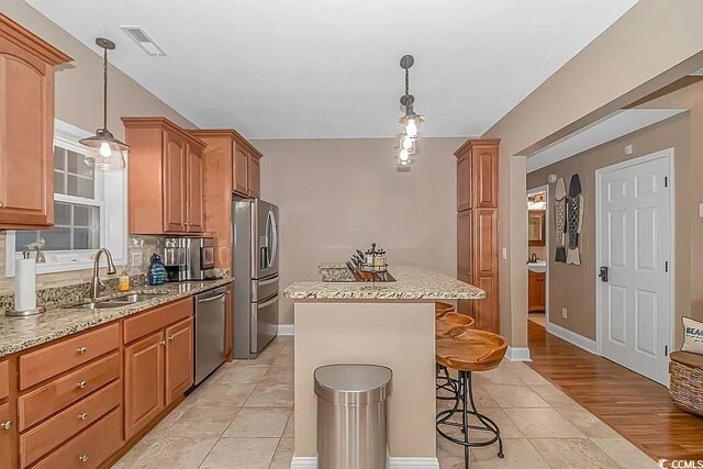 3815 Ed Smith Ave, Myrtle Beach, SC 29588 - kitchen with a breakfast bar area, a sink, appliances with stainless steel finishes, visible vents, and a center island