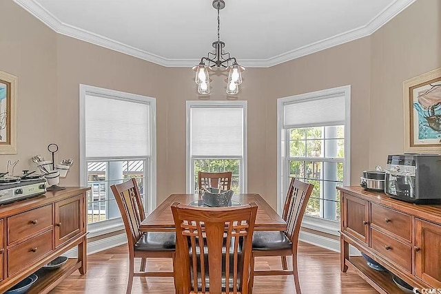 dining area featuring light hardwood / wood-style flooring, a notable chandelier, and ornamental molding