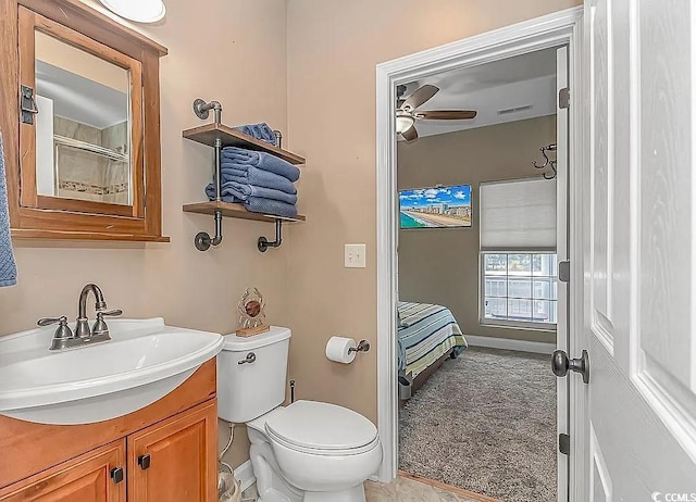 bathroom with walk in shower, vanity, toilet, and ceiling fan