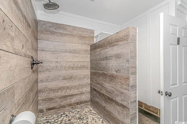 bathroom with a shower and wood walls