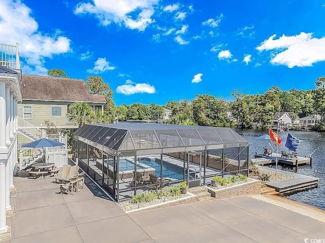 view of swimming pool with a lanai, a water view, and a patio area