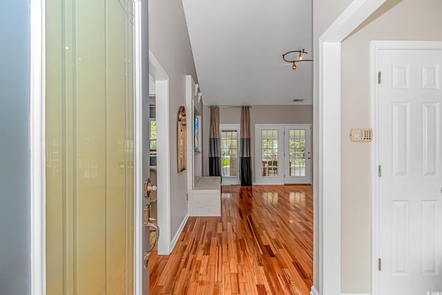 entryway with light hardwood / wood-style floors and vaulted ceiling