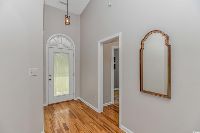 foyer entrance featuring light hardwood / wood-style flooring and a high ceiling