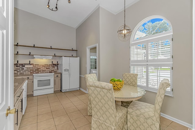 kitchen featuring white cabinetry, range hood, decorative light fixtures, white appliances, and light tile patterned floors