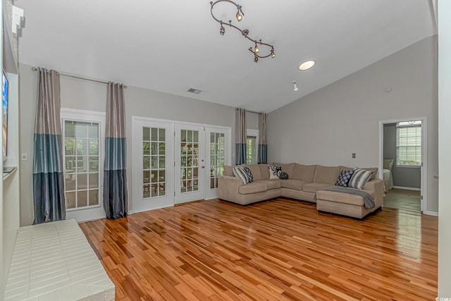 unfurnished living room with light wood-type flooring and high vaulted ceiling