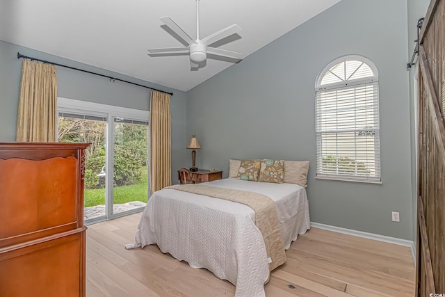 bedroom with ceiling fan, a barn door, lofted ceiling, access to outside, and light wood-type flooring