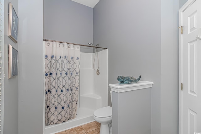 bathroom with toilet, tile patterned flooring, and a shower with shower curtain