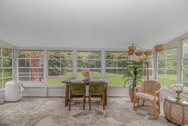 sunroom / solarium with a healthy amount of sunlight and lofted ceiling